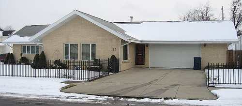Une maison de banlieue américaine en hiver, avec une large allée de garage dépourvue de neige